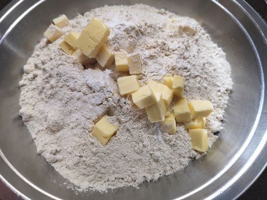 butter cubes added into the flour to knead a dough