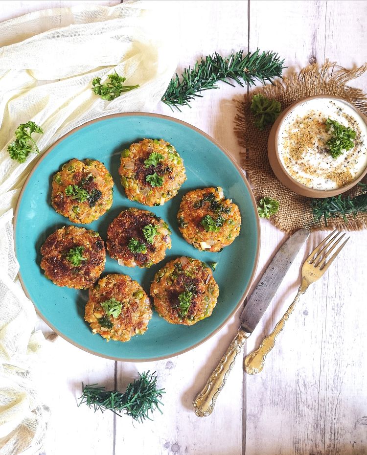 overhead view of nutritious Carrot and Peas Fritters served on a turquoise plate with yogurt dip