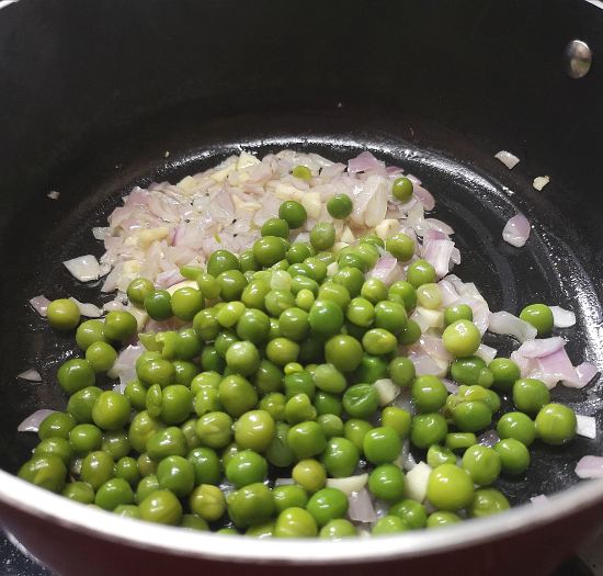 adding boiled green peas to carrot and peas fritters