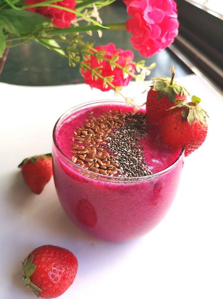  Strawberry and Dragon Fruit Smoothie garnished with chia seeds, flax seeds and ready be served. benefits of strawberry