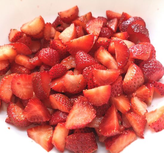 close up look of hulled and chopped fresh strawberries for preparing Strawberry Oats Crumble