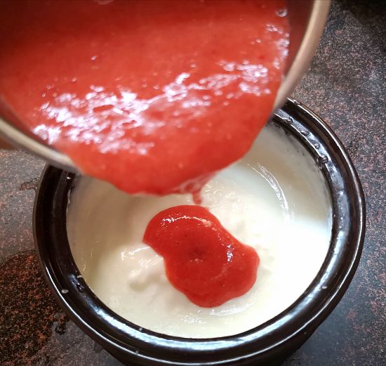 adding strawberry puree in the yogurt