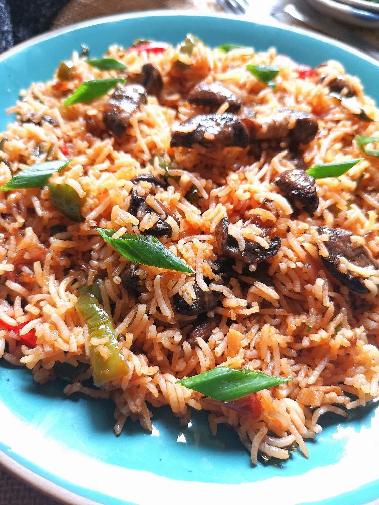 close up view of Mushroom Fried Rice served in a turquoise plate, ready to be served