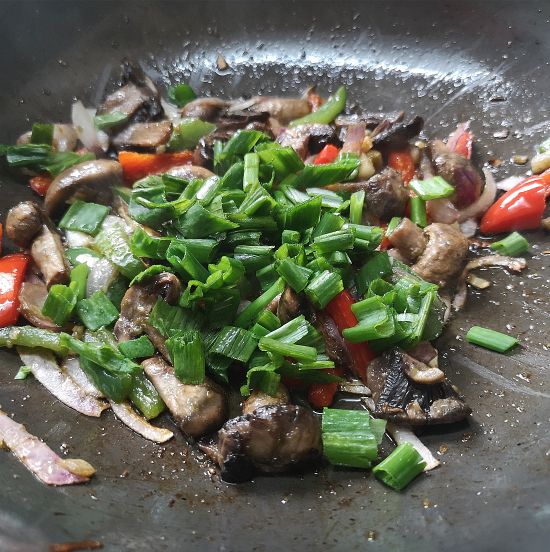adding soya sauce, vinegar, spring onions to mushroom fried rice