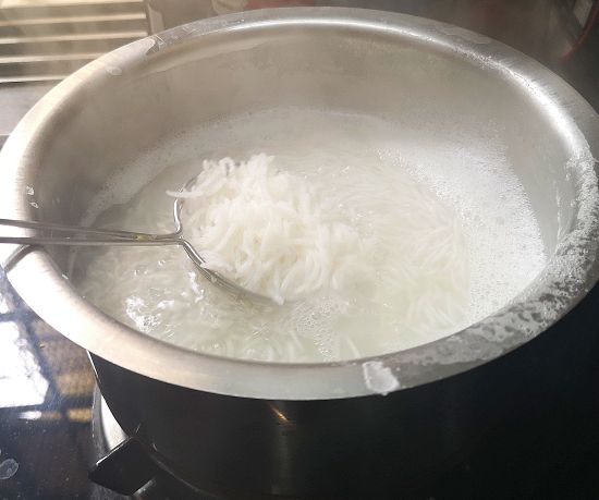 basmati rice being cooked in boiling water for mushroom fried rice