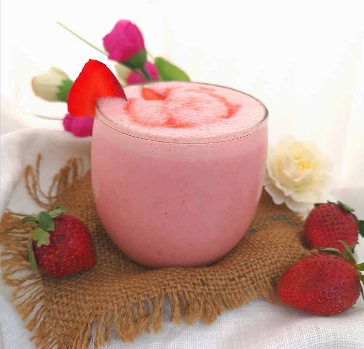How to make Strawberry Lassi, front close up view of strawberry lassi with drizzle if strawberry juice