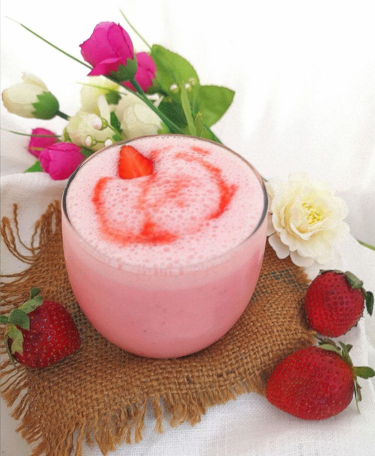 close up view of frothy and creamy Strawberry Yogurt Drink topped with fresh strawberry
