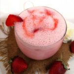 close up view of frothy and creamy Strawberry Yogurt Drink topped with fresh strawberry