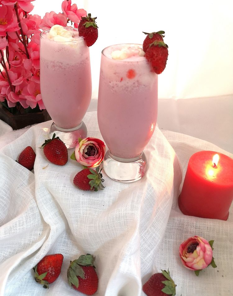close up view of creamy and frothy Strawberry Milkshake served into 2 glasses and topped with fresh strawberries, How to make Strawberry Milkshake 