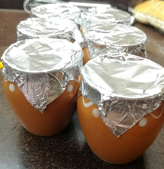 covering mango matka kulfi with aluminium foil, ready to be freezed