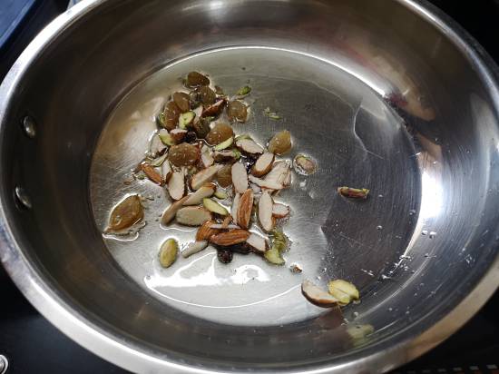 roasting almonds and raisins in hot ghee for Sheer Khurma