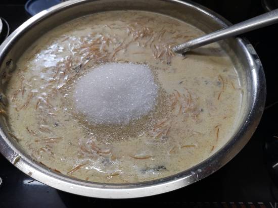 adding sugar in boiled milk and cooked vermicelli for sheer kurma