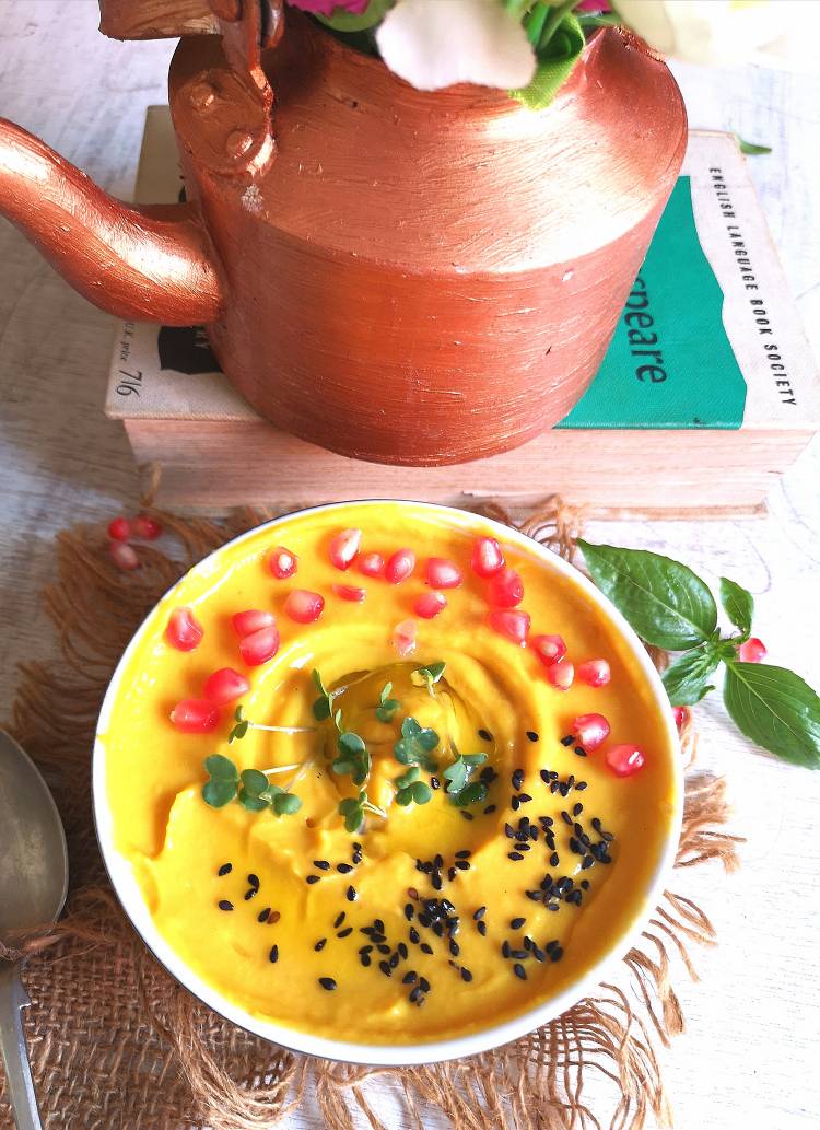 close up of mango hummus served in a bowl and places on a jute cloth
