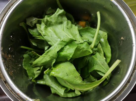 adding spinach leaves in mango spinach smoothie recipe