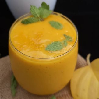 close up view of Mango Turmeric Smoothie garnished with fresh mint leaves, Benefits of Turmeric