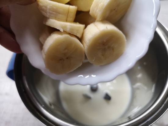 adding chopped bananas along with milk into the blender for Strawberry Banana Milkshake
