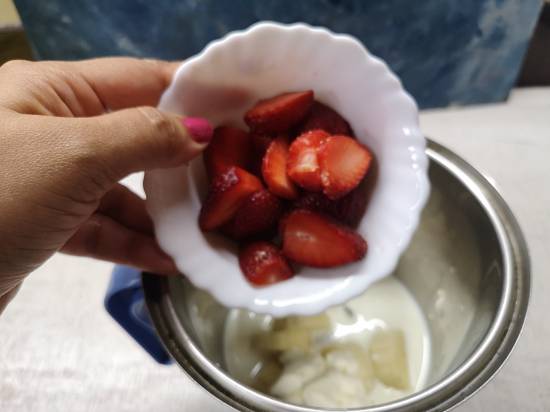 adding strawberries to the blender for Strawberry Banana Milkshake