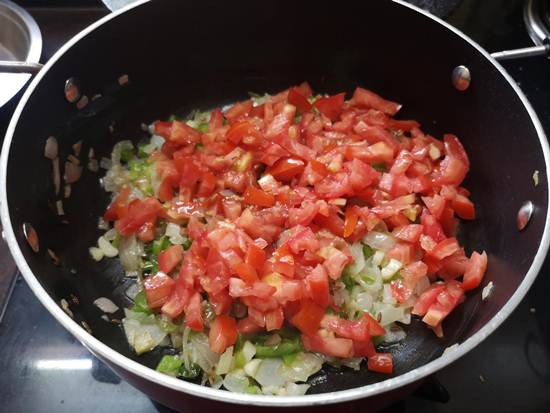 adding chopped tomatoes for paneer bhurjee recipe