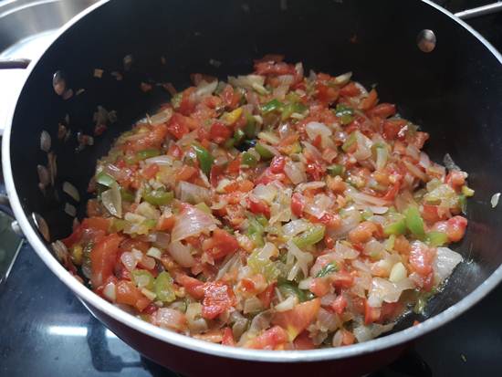 Cooking tomatoes, capsicum and onion together till musht for paneer bhurjee recipe