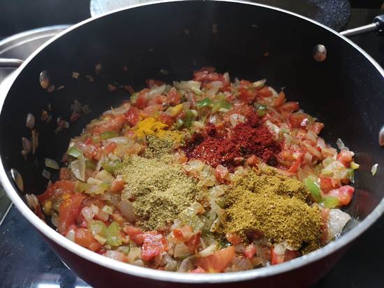 adding turmeric powder, red chili powder, garam masala to paneer bhurjee sabzi